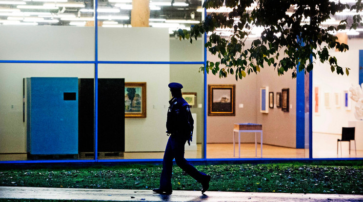 Korabeli fotó a rablás helyszínéről: A rotterdami Kunsthal múzeum előtt megy egy rendőr 2012. október 16-án, miután az előző éjszaka hét nagyértékű festményt, Pablo Picasso, Henri Matisse, Claude Mone, Paul Gauguin, Meyer de Haan és Lucian Freud műveit lopták el ismeretlen tettesek a képtárból. /  (MTI/EPA/Robin Utrecht)