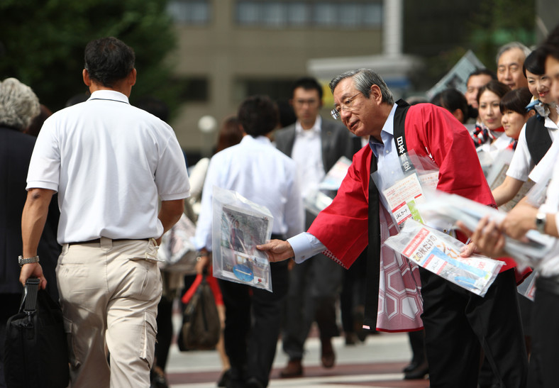Haruka Nishimats, prezes zarządu Japan Airlines rozdający ulotki porannym przechodniom w Tokio