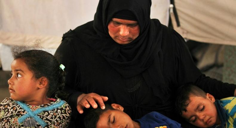 Salima, a 36-year-old mother of four living in the Laylan 2 displacement camp, sits with her children in their tent at the camp, southeast of Kirkuk in northern Iraq