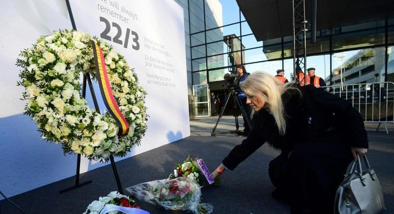 A woman places a bunch of flowers during a memorial at Brussels' international airport in Zaventem