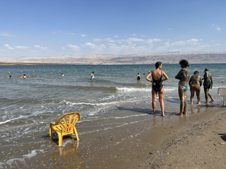 Plaża nad Morzem Martwym, na zdjęciu widać już ludzi, którzy czekają aż błoto wyschnie. Wtedy można je zmyć