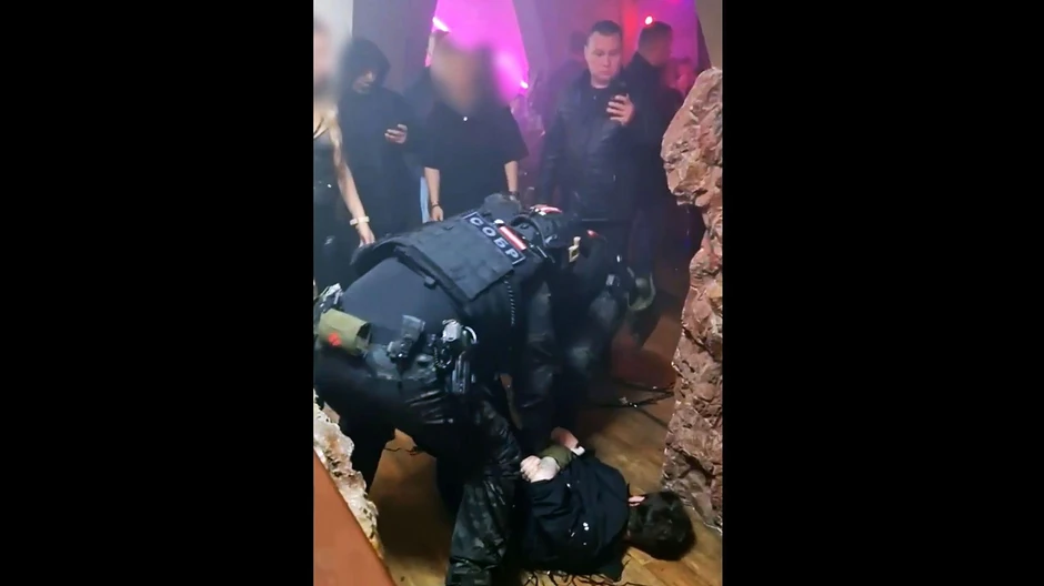 Pripadnici policije (na slici drže gosta prikovanog za pod) pridružili su se upadu na Katjinu žurku | Foto: BBC
