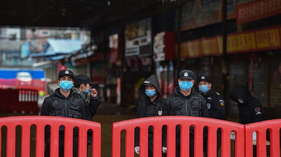 Chińscy policjanci przed wejściem na zamknięty targ w Wuhan, 24 stycznia 2020 r.