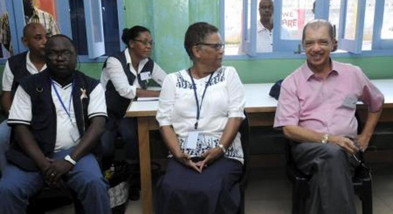 Seychelles President James Michel (R) talks to lawyer Alexia Antao at a voting centre during the presidential polls in Victoria, Seychelles, December 3, 2015.