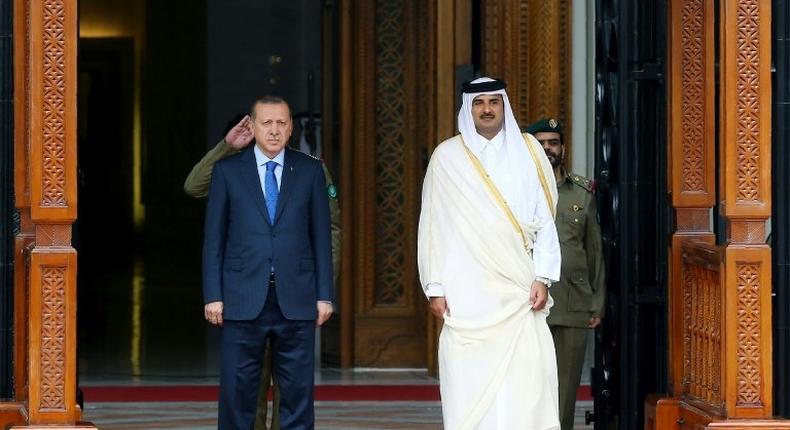 This handout photo taken and released by Turkey's Presidential Press Service on February 15, 2017 shows the Emir of Qatar Tamim bin Hamad Al Thani (R) and Turkish President Recep Tayyip Erdogan (L) attending a welcome ceremony in Doha