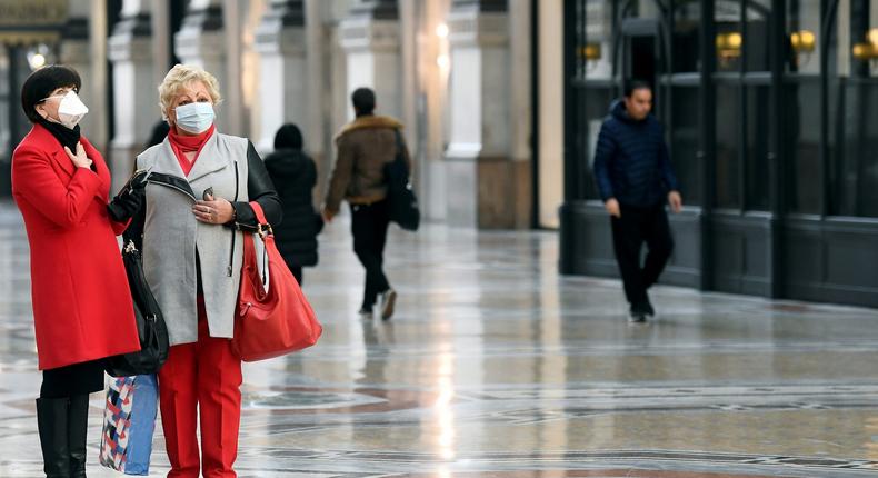 FILE PHOTO: Women in face masks are seen in Galleria Vittorio Emanuele II, after the Italian government imposed a virtual lockdown on the north of the country, in Milan, Italy March 8, 2020. REUTERS/Flavio Lo Scalzo/File Photo