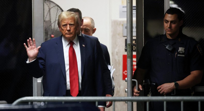 Donald Trump waves to reporters as he enters the courtroom for his hush-money trial in New York.Reuters/Spencer Platt