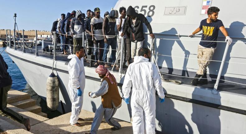 Migrants disembark in October 2019 from a Libyan coast guard ship in the town of Khoms, part of the instability that has led the United States to impose sanctions on smugglers