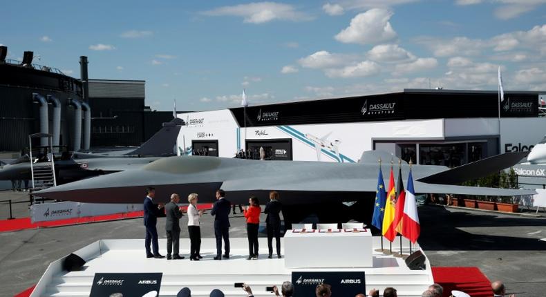 French President Emmanuel Macron, third from right, joined other officials in front of a full-scale model of new jet for Europe's Future Combat Air System (FCAS) at the Paris Air Show on Monday