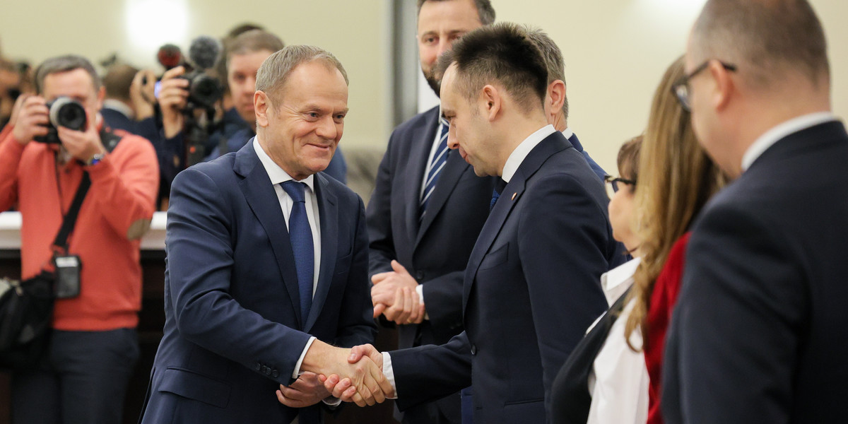 Premier Donald Tusk wita się z ministrem finansów Andrzejem Domańskim przed rozpoczęciem posiedzenia rządu. 3 stycznia 2024 r.