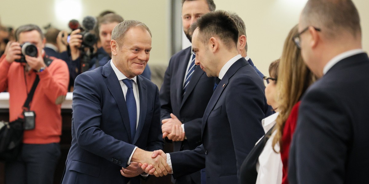 Premier Donald Tusk wita się z ministrem finansów Andrzejem Domańskim przed rozpoczęciem posiedzenia rządu. 3 stycznia 2024 r.