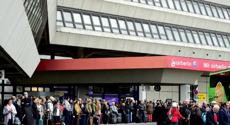 Passengers queue for bus transport during a wage strike by ground staff at Berlin's Tegel airport on March 10, 2017