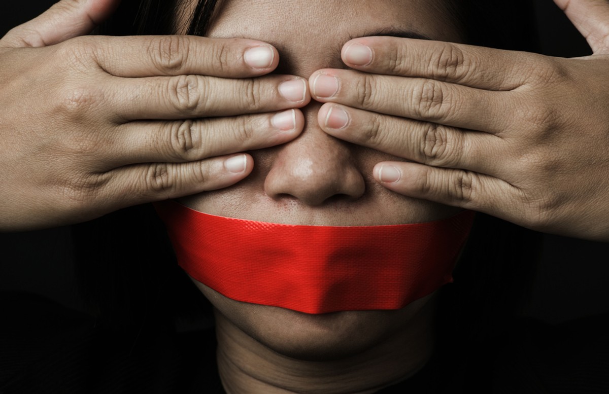 Asian,Woman,Blindfold,Wrapping,Mouth,With,Red,Adhesive,Tape,On