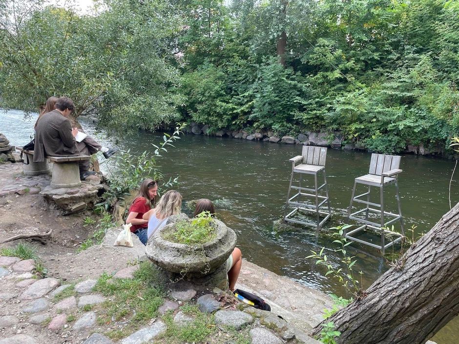 Posetioci Užupisa kraj reke Vilije, a tu su i umetničke postavke u vidu dve spasilačke stolice | Foto: Nemanja Mitrović