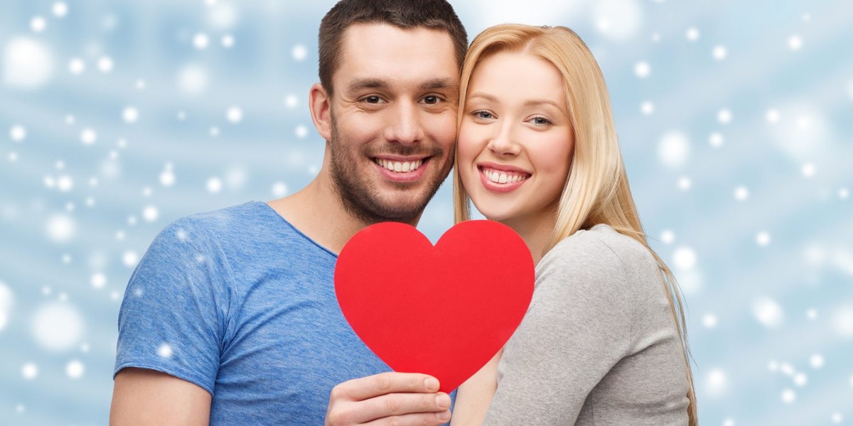 happy couple with red heart shape hugging outdoors