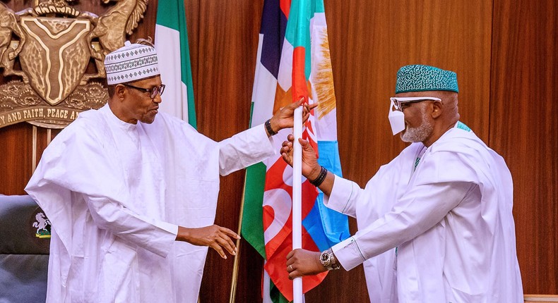 President Muhammadu Buhari presents All Progressives Congress (APC)'s flag to Ondo state Governor, Rotimi Akeredolu. [Twitter/@NigeriaGov]  