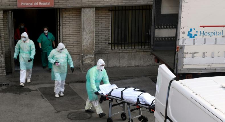 A health worker carries a body on a stretcher outside Gregorio Maranon hospital in Madrid