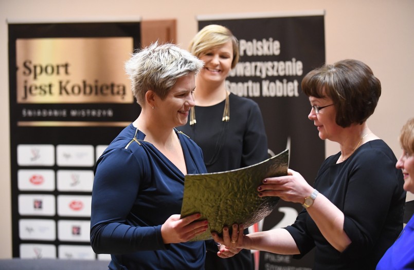 Prezes Polskiego Stowarzyszenia Sportu Kobiet Otylia Jędrzejczak (C) oraz Joanna Sobiecka (P) wręczają nagrodę dla najlepszej zawodniczki 2016 roku mistrzyni olimpijskiej i rekordzistce świata w rzucie młotem Anicie Włodarczyk (L)