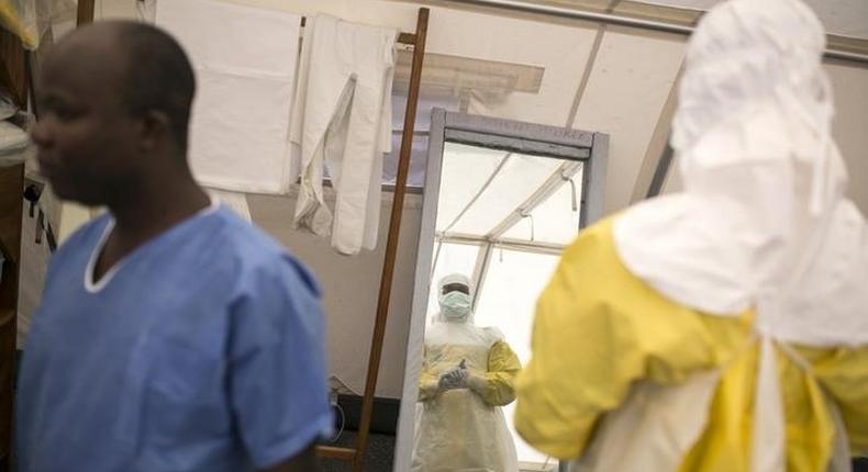 Health workers put on protective gear before entering a quarantine zone at a Red Cross facility in the town of Koidu, Kono district in Eastern Sierra Leone December 19, 2014. REUTERS/Baz Ratner