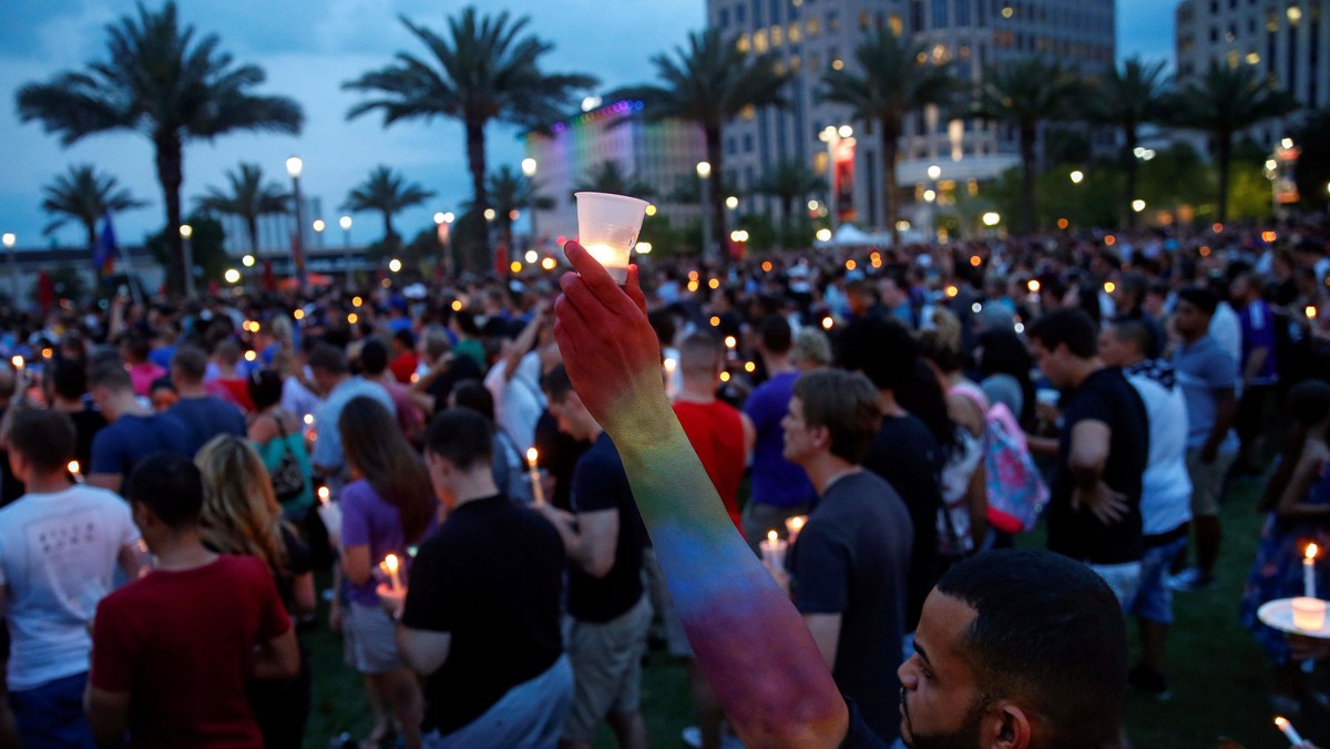 Man raises a candle during a vigil in memory of victims one day after a mass shooting in Orlando, Fl