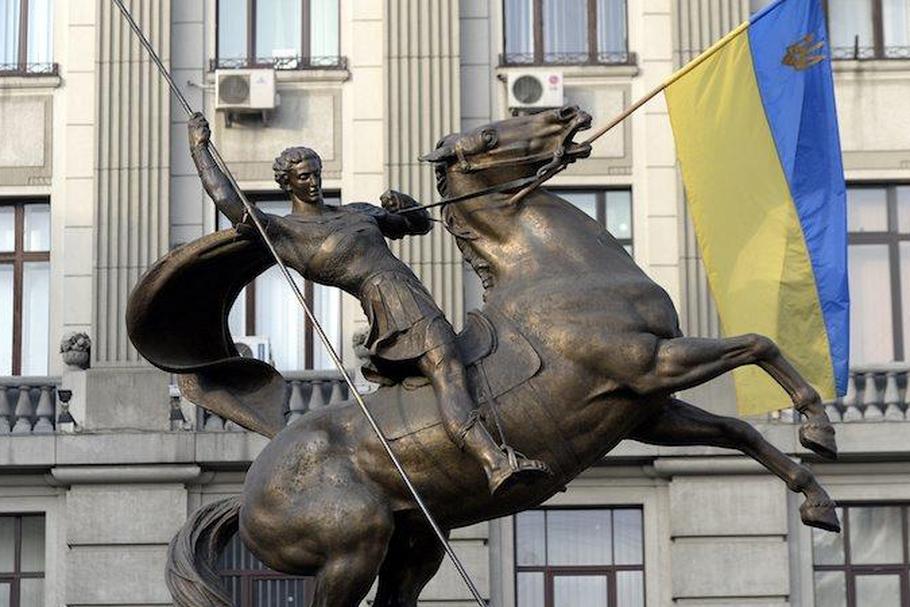 Ukraińska flaga zatknięta na pomniku św. Jerzego zwyciężającego smoka przy siedzibie MSW Ukrainy