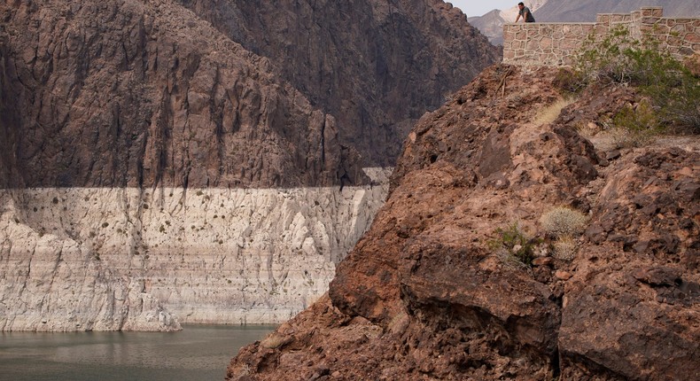 A person looks out over Lake Mead on August 13, 2021. The bathtub ring of light minerals shows the high water mark of the reservoir which has fallen to record lows.