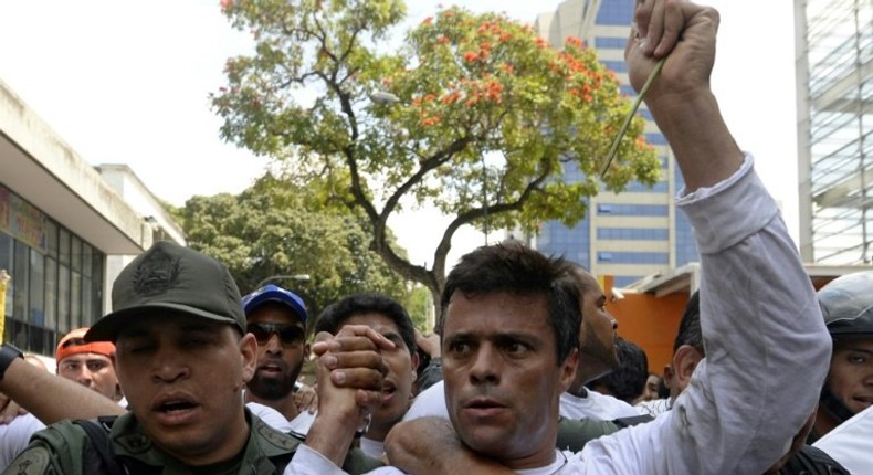 This photo taken on February 18, 2014 shows Venezuelan opposition leader Leopoldo Lopez (R) as he is escorted by the National Guard after turning himself in, during a demonstration in Caracas