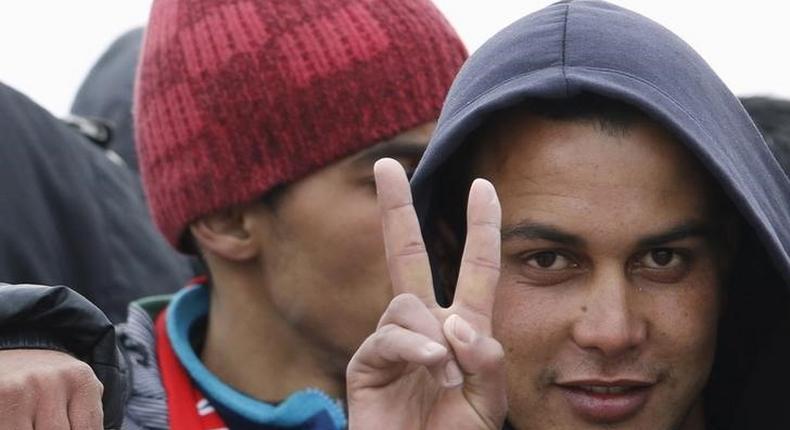 Moroccan citizen Touil Abdelmajid makes a victory sign as he arrives with migrants on the Italian navy ship Orione at Porto Empedocle harbour in Sicily February 17, 2015. Italian police said on May 20, 2015 they had arrested the 22-year-old Moroccan man suspected of involvement in the March 18 attack on the Bardo museum in Tunis which killed 20 tourists. Police in Milan said the man, named as Abdelmajid, had been sought by authorities in several countries. Picture taken February 17, 2015. REUTERS/Antonio Parrinello