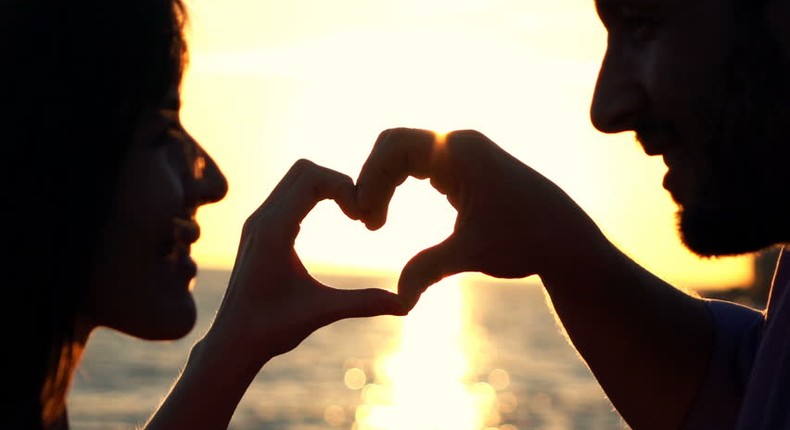 Couple making heart symbol with hands (Courtesy)