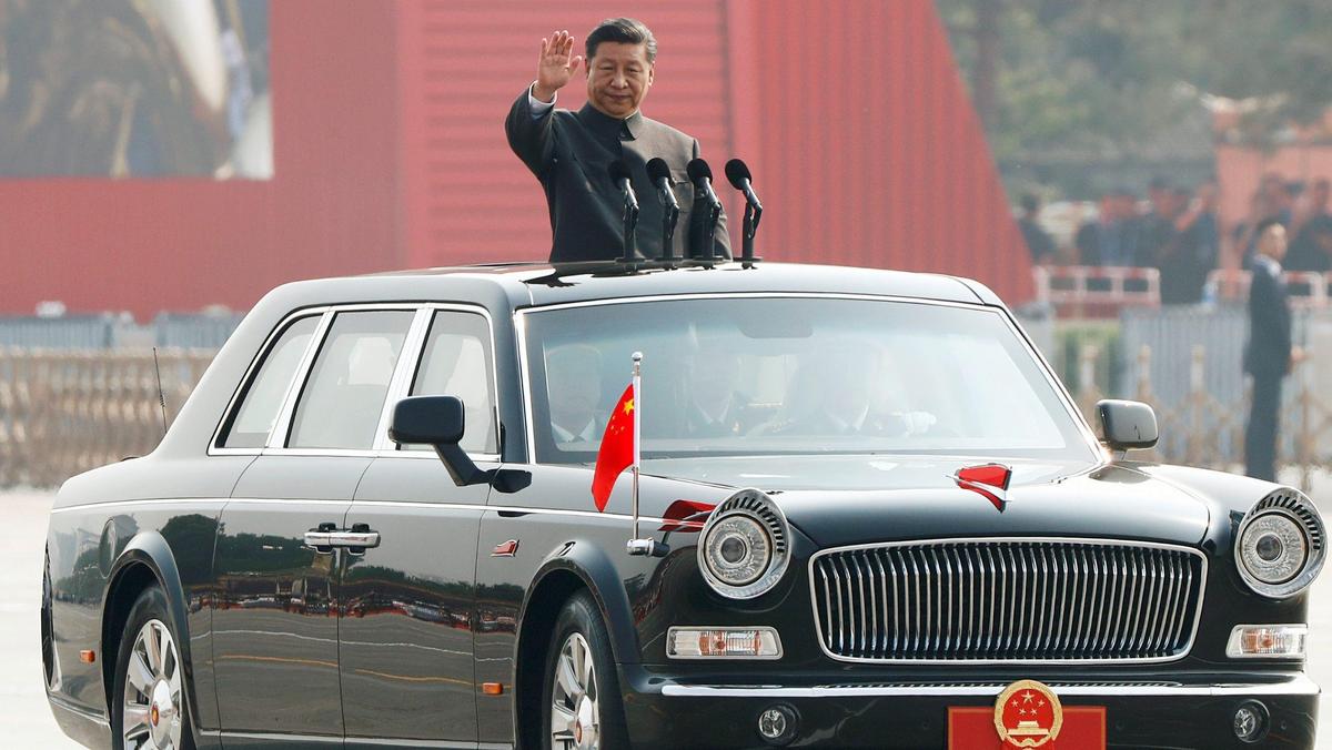 Chinese President Xi Jinping waves from a vehicle as he reviews the troops at a military parade marking the 70th founding anniversary of People's Republic of China