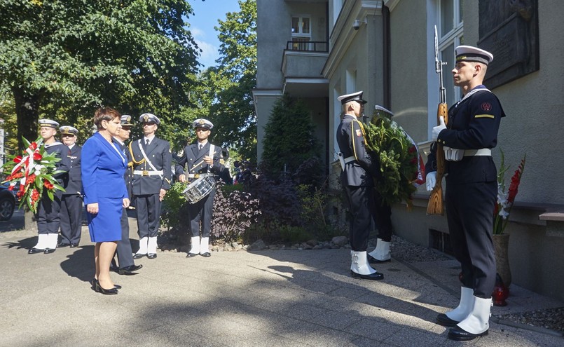 Premier Beata Szydło składa kwiaty przed tablicą upamiętniającą Lecha Kaczyńskiego