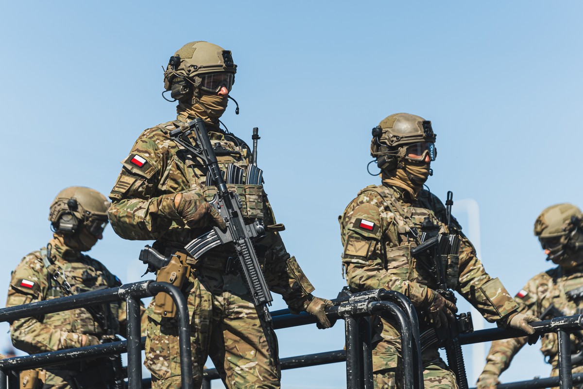Zapad 2025. Grupa uzbrojonych żołnierzy w pełnym umundurowaniu i hełmach taktycznych stoi na platformie pojazdu wojskowego.