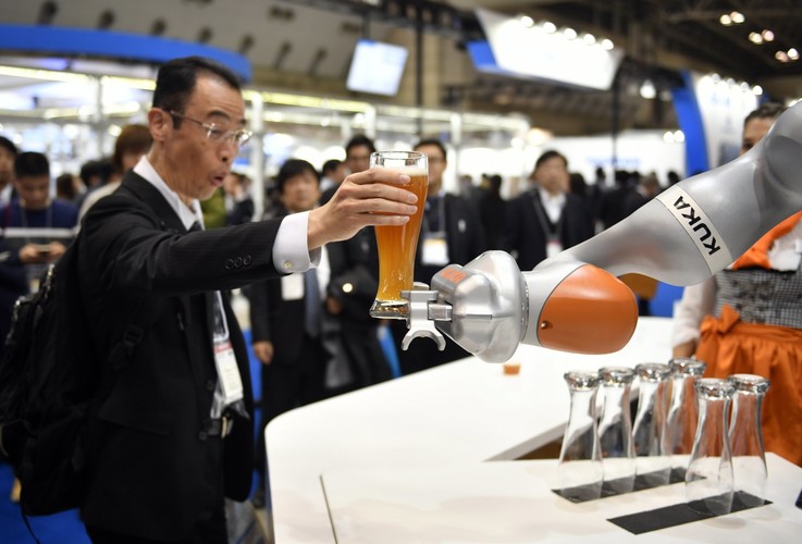 Robot przemysłowy niemieckiej firmy Kuka serwuje piwo podczas występu na Międzynarodowej Wystawie Robotów w Tokio