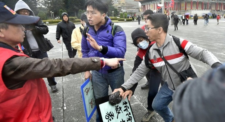 An activist (left) favouring unification with China clashes with pro-unification activists on the 70th anniversary of the 228 incident at the Chiang Kai-shek Memorial Hall in Taipei on February 28, 2017