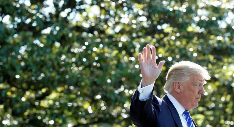 U.S. President Donald Trump waves as he walks on the South Lawn of the White House in Washington