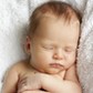 newborn baby sleeping on a white blanket