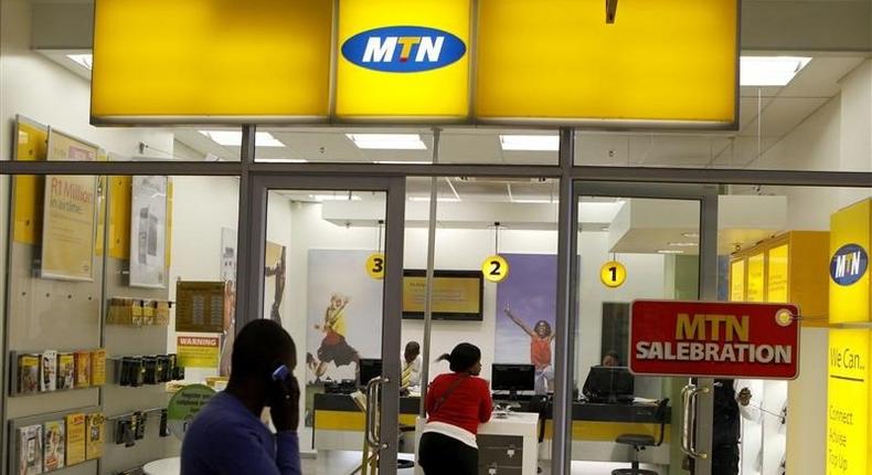 A man speaks on a mobile phone as he walks past a MTN shop at a shopping mall south of Johannesburg June 6, 2012. Africa's biggest wireless phone operator, MTN Group, said a Liberian court has stopped the country's telecoms regulator from suspending the company's licence, but the watchdog insisted the suspension remained on track. The Liberia Telecommunication Authority (LTA) said last month it would suspend the operating licence for South Africa's MTN for two weeks after the company cut off its competitor, Comium, accusing it of unpaid interconnection fees. Picture taken June 6.       REUTERS/Siphiwe Sibeko (SOUTH AFRICA - Tags: BUSINESS TELECOMS)