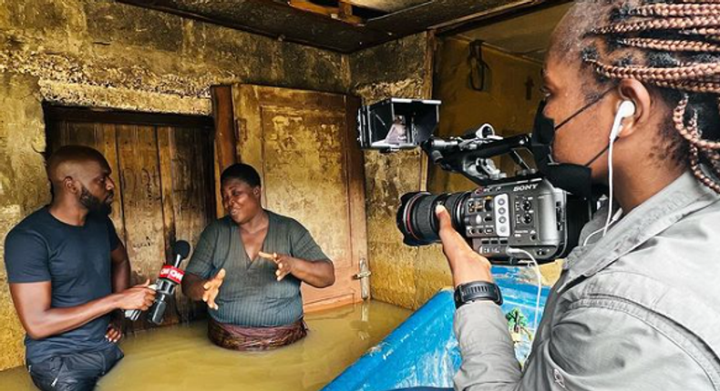 Larry Madowo interviewing a woman for a story 