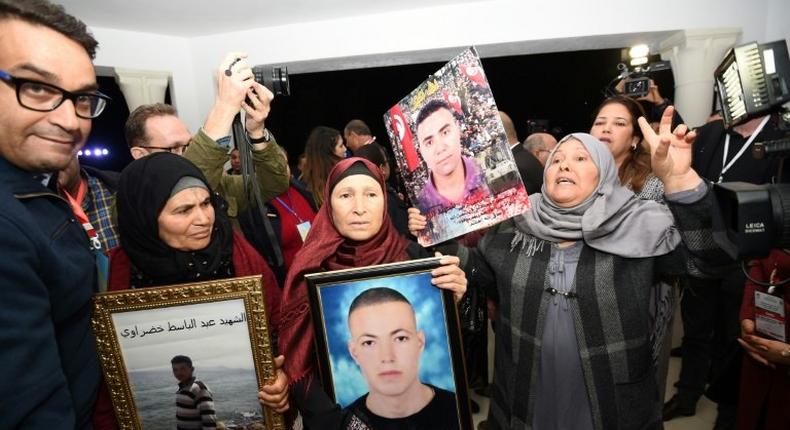 Tunisian mothers of torture victims carry their sons' portraits at the The Truth and Dignity Commission in Tunis