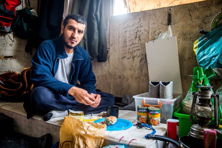 Uchodźca w swojej budce, którą dzieli z 8 innymi osobami