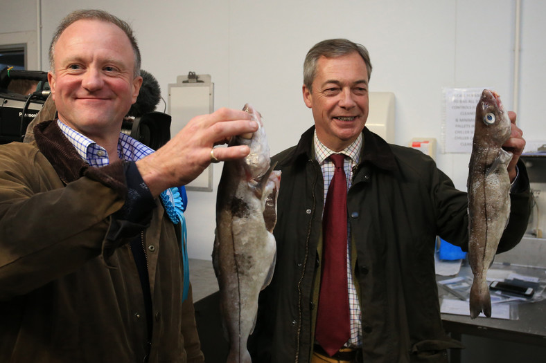 Lider Partii Brexitu Nigel Farage (po prawej), w towarzystwie Chrisa Barkera (także z Partii Brexitu) trzyma rybę podczas kampanii wyborczej w Grimsby, 14 listopada 2019 r.