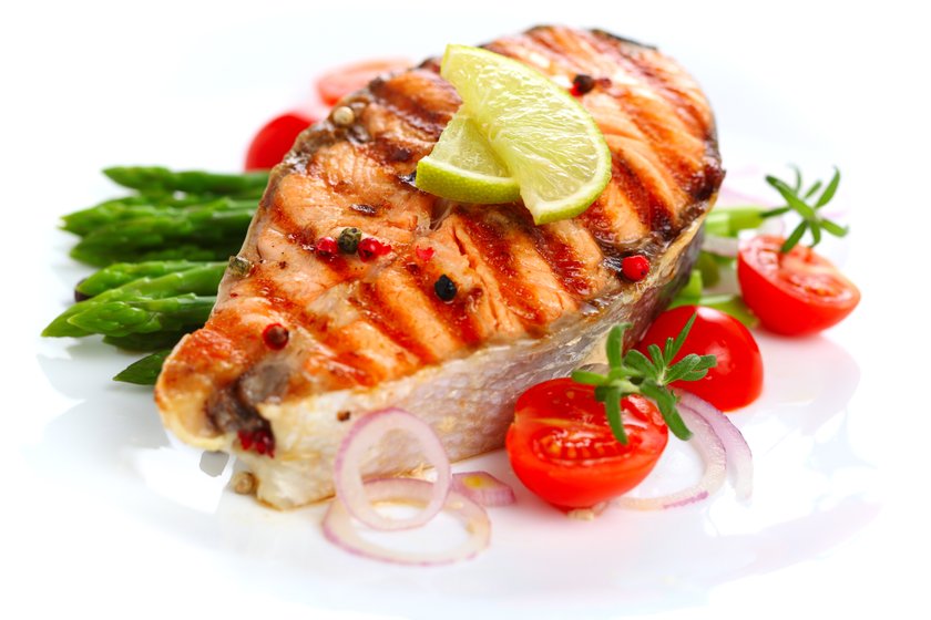 Grilled salmon with lime, asparagus and cherry tomatoes on white