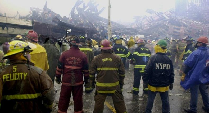 Firemen and rescuers work at the base of the World Trade Center in the early morning September 14, 2001, in New York