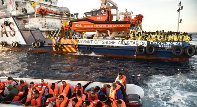 Maltese activists help migrants to board a small rescue boat during a rescue operation off the coast of Libya, on November 5, 2016