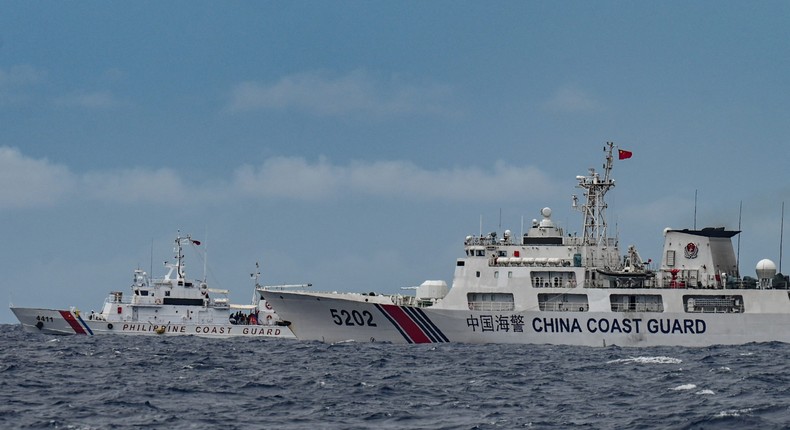 A Chinese vessel passes a Philippine Coast Guard ship in the disputed waters of the South China Sea on August 26, 2024.JAM STA ROSA/AFP via Getty Images