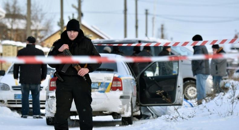 An armed policeman stands guard in the town of Knyazychy, about 30 kilometres east of Kiev, on December 4, 2016