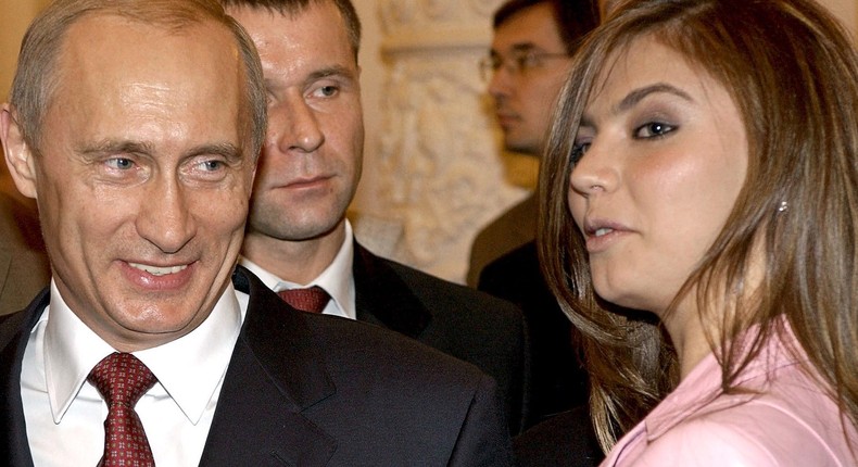 Russian President Vladimir Putin (L) smiles next to Russian gymnast Alina Kabaeva in 2004.