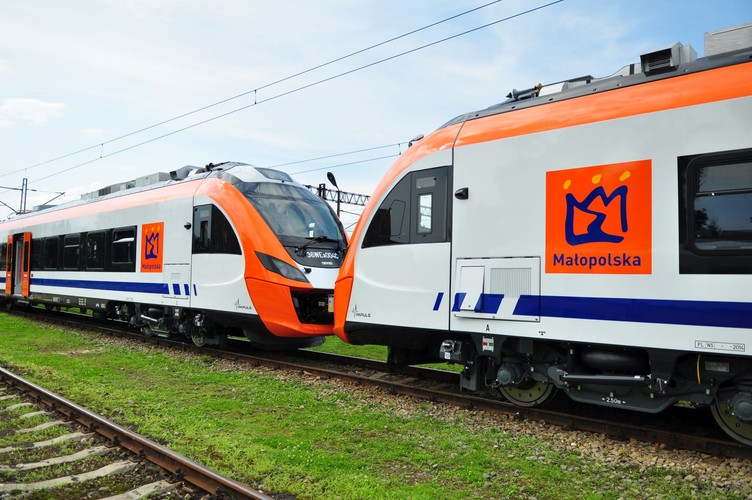 A to też elektryczne zespoły trakcyjne Impuls, też dla Małopolski, ale w poprzednim malowaniu. Te pociągi obsługują m.in. trasę między Krakowem i Tarnowem. Przewoźnik zdecydował się na inny wygląd swoich składów, ale zmiana tzw. malatury będzie się odbywała dopiero przy okazji napraw głównych. <br><br>
Koleje Małopolskie wożą pasażerów od jesieni 2014 r. Spółka używa obecnie 14 elektrycznych pociągów (Impuls i Acatus), które są własnością samorządu. Obsługa kolejowa Małopolski nie jest jednak możliwa bez tamtejszego oddziału dawnych Przewozów Regionalnych (dziś spółka nazywa się PolRegio).<br><br> 
 Na zdj. Składy Impuls dla Małopolski przed zmianą malowania