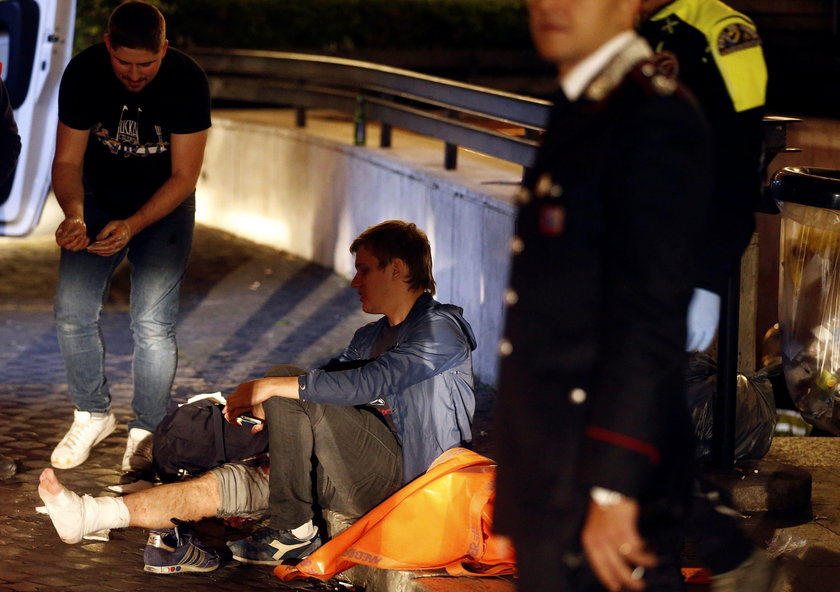 Fire fighters and medical staff member carry an injured person outside the underground where some of