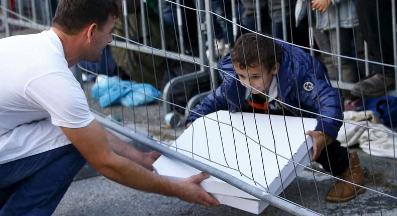 The kind gesture of a waiter delivering pizza to a group of migrants and refugees waiting behind a fence goes viral.